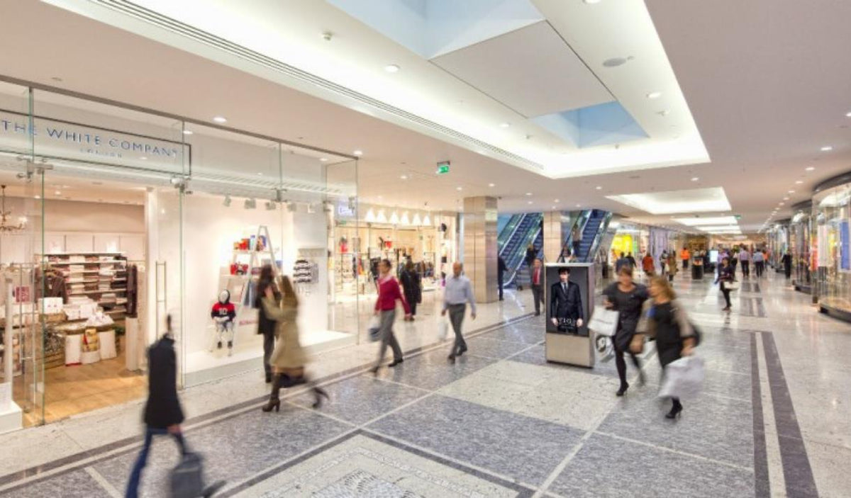 Shoppers walking through a busy indoor shopping centre