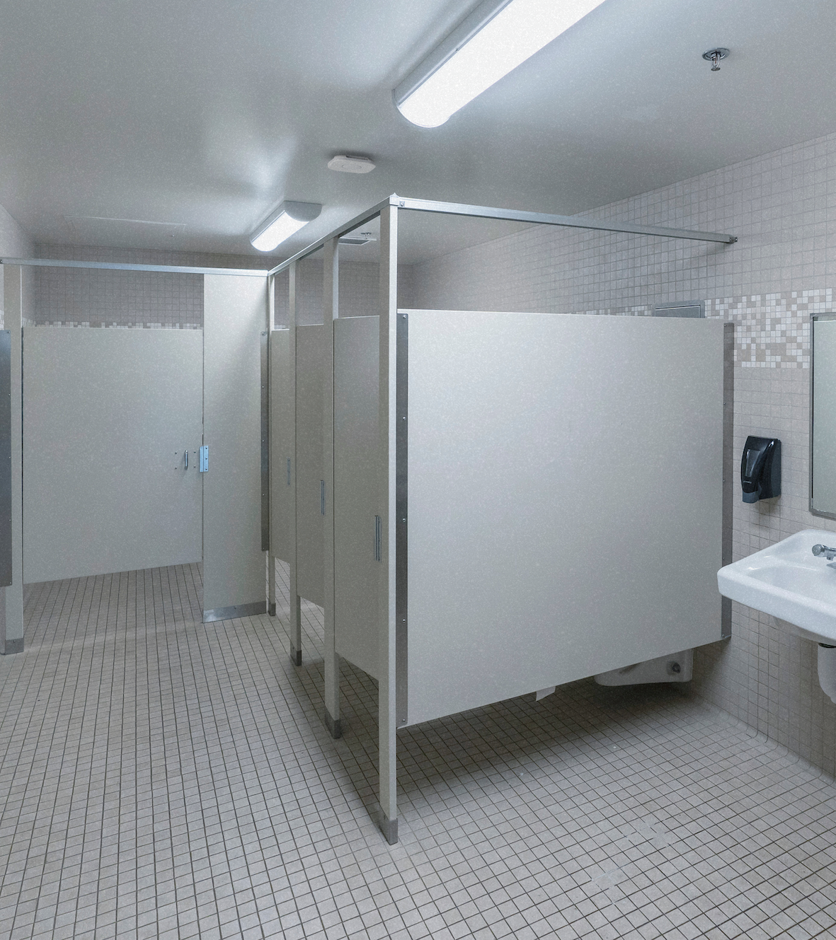 Empty school toilet block with cubicles and washbasins